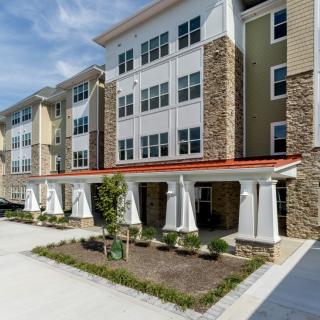 A modern multi-story apartment building with a brick and siding exterior.