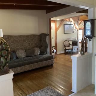 A cozy living room featuring a patterned couch, wooden flooring, and traditional decor.