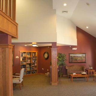 A cozy lobby interior with a seating area, bookshelf, and decorative elements.