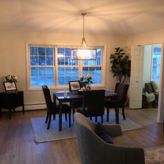 A cozy dining room with a modern light fixture and elegant decor.