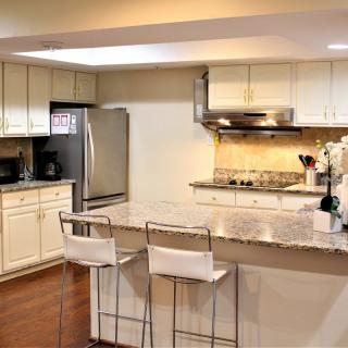 Modern kitchen with stainless steel appliances and a breakfast bar.