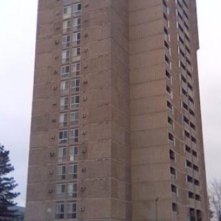 A concrete residential tower showcasing modern architectural design.