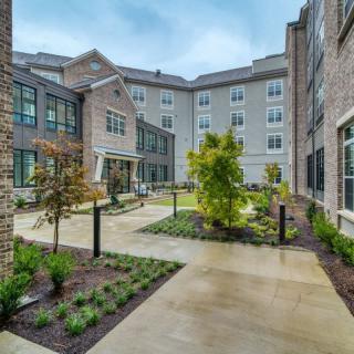 A modern courtyard with a landscaped garden in an urban residential building complex.