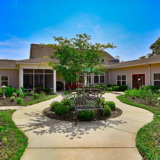 A well-maintained residential building with landscaped gardens and a central pathway.