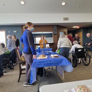 A community gathering with seniors enjoying food and conversation.