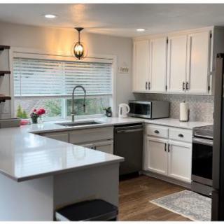 A modern kitchen with white cabinets and stainless steel appliances.