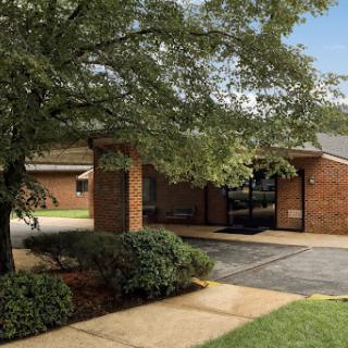 A welcoming brick building with landscaped surroundings and a clear entrance.