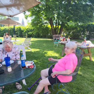 People relaxing in a garden setting on a sunny day.