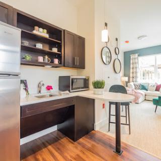 A stylish and modern kitchen featuring sleek cabinetry, essential appliances, and a cozy dining area.