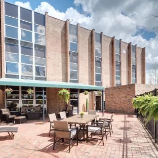 Modern building with a furnished outdoor patio area on a sunny day.