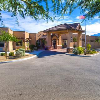 A sunny day view of a building entrance surrounded by desert landscaping.