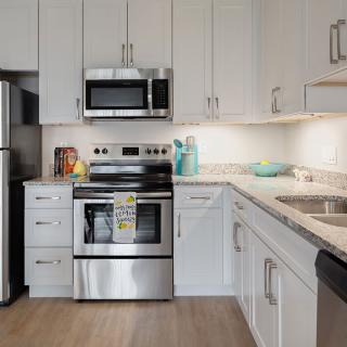 A modern kitchen with stainless steel appliances and white cabinetry.