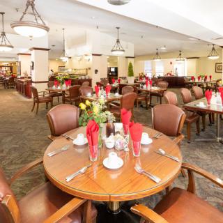A well-decorated dining area with set tables and chairs, prepared for guests.