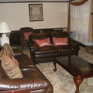 A cozy living room with leather sofas and a dark wood coffee table.
