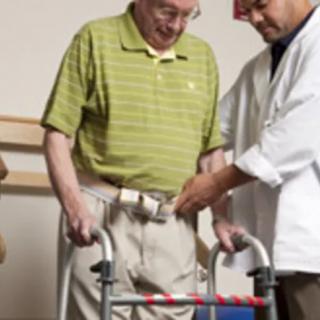 A therapist assists an elderly person with a walker during a rehabilitation session.