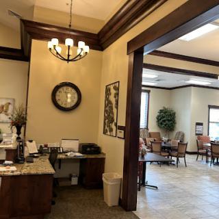 A warm and inviting office reception area with modern furnishings and a classic chandelier.