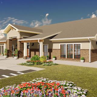 A modern residential building with landscaped gardens and colorful flowers in front.
