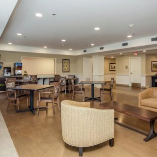 A cozy seating area with tables and chairs, featuring soft indoor lighting.