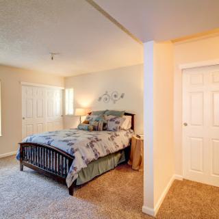 A cozy and well-decorated bedroom featuring a comfortable bed and soft carpeting.
