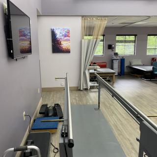 A physical therapy room equipped with parallel bars and exercise equipment.