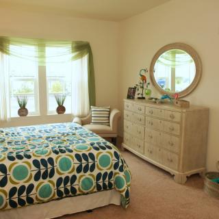 A cozy bedroom with colorful bedding and stylish furniture.