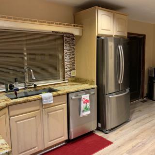 A modern kitchen with stainless steel appliances and wooden cabinetry.