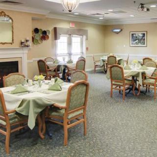 A neatly arranged dining area with multiple tables and chairs, featuring elegant table settings.