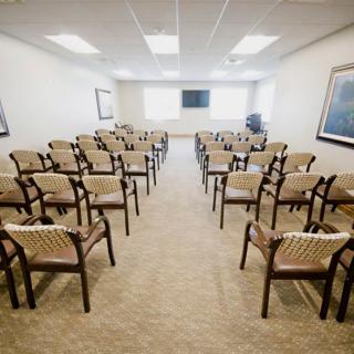 An empty conference room with rows of chairs arranged for a meeting.