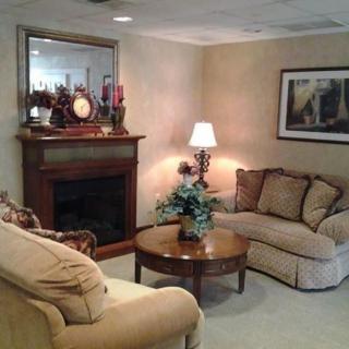 A cozy living room with a fireplace, sofas, and a coffee table adorned with decorative items.