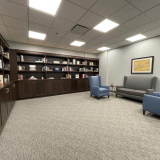 A cozy office lounge with bookshelves and comfortable seating.