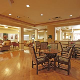 A spacious dining and lounge area with elegant wood flooring and comfortable seating.