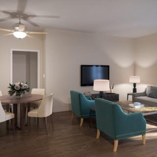 A modern living room and dining area featuring a gray sofa, teal armchairs, a wooden coffee table, a flat screen TV, and a round dining table with white chairs.