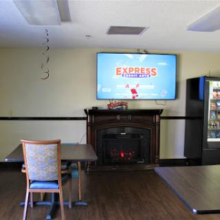 A cozy lounge space featuring a television, fireplace, and vending machine.