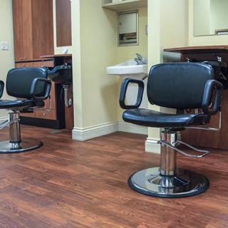 An interior view of a barbershop with styling chairs and mirrors.