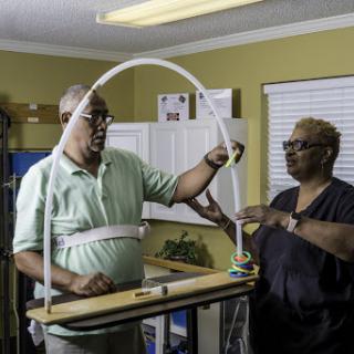 A man and a woman collaborate to set up or adjust a piece of equipment in a workspace.
