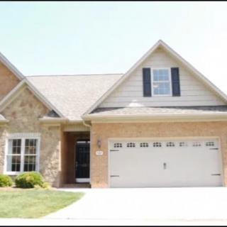 A modern brick house with a two-car garage and a well-maintained lawn.