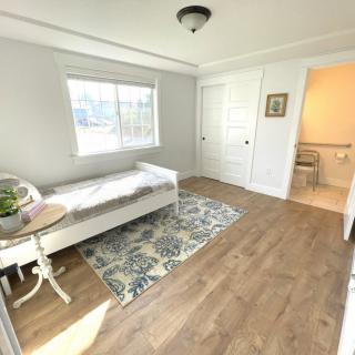 Bright bedroom with a daybed, hardwood floors, and a decorative rug.