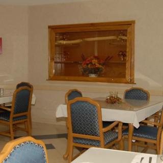 A cozy dining area with neatly arranged tables and chairs, featuring a decorative element on the wall.