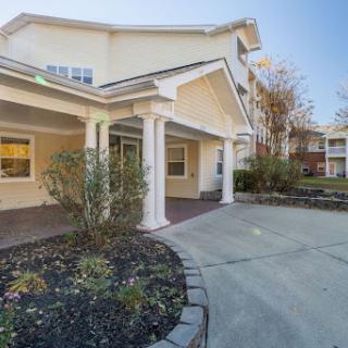 A welcoming entrance to a residential building with landscaped surroundings.