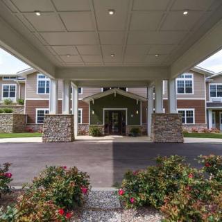 The entrance to a modern residential building with well-maintained landscaping.