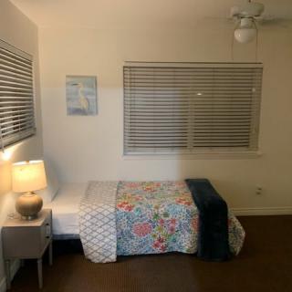 A cozy bedroom with a single bed, minimalist decor, and soft lighting.