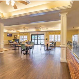 Spacious dining area with wooden flooring and bright lighting.