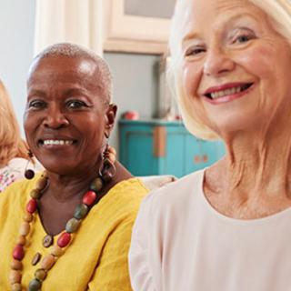 Two smiling senior women enjoying each other's company indoors.