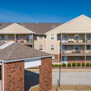 A residential apartment building with balconies and a covered entrance.
