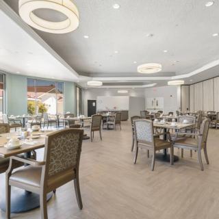A modern and spacious restaurant dining area with neatly arranged tables and chairs.