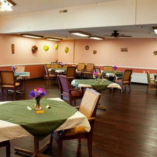 A cozy dining area with neatly arranged tables and chairs, decorated in warm tones.