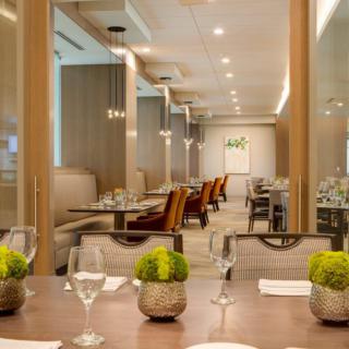 A modern restaurant interior featuring an elegant dining area with neatly set tables and contemporary decor.