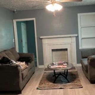 A cozy living room featuring two sofas, a coffee table, and a fireplace.
