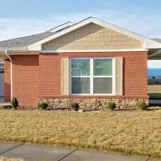 A single-story brick house with a large window and a small front yard.
