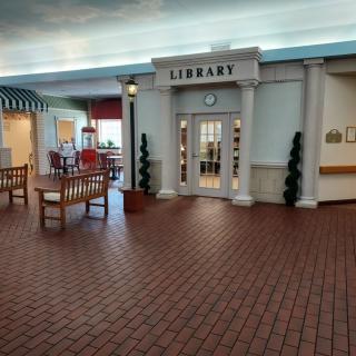 An indoor library setting with seating areas and architectural features.
